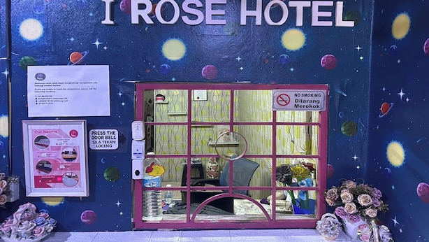Das Hotel I Rose mit einer Weltraum-Muralmalerei, einer Rezeption und einem Rauchverbot-Schild.
