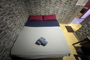 Escritorio, tabla de planchar con plancha y ropa de cama 