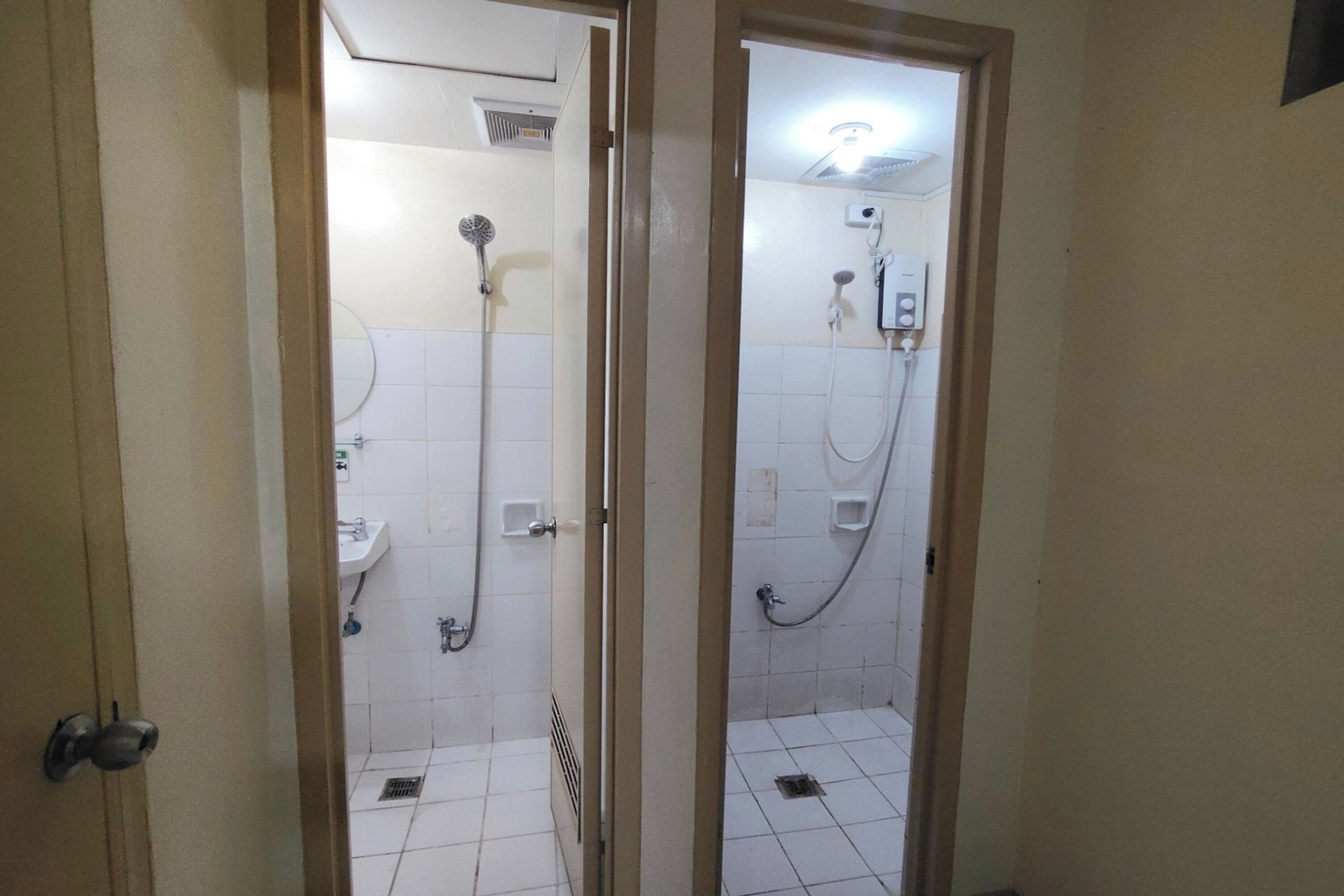 A bathroom with two shower stalls, a sink, and a toilet.