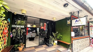 Entrada de hotel com balcão de recepção e aviso de quartos disponíveis.