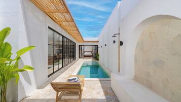 Una piscina al aire libre, sillones reclinables de piscina