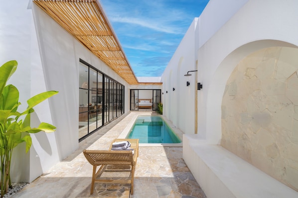 Una piscina al aire libre, sillones reclinables de piscina