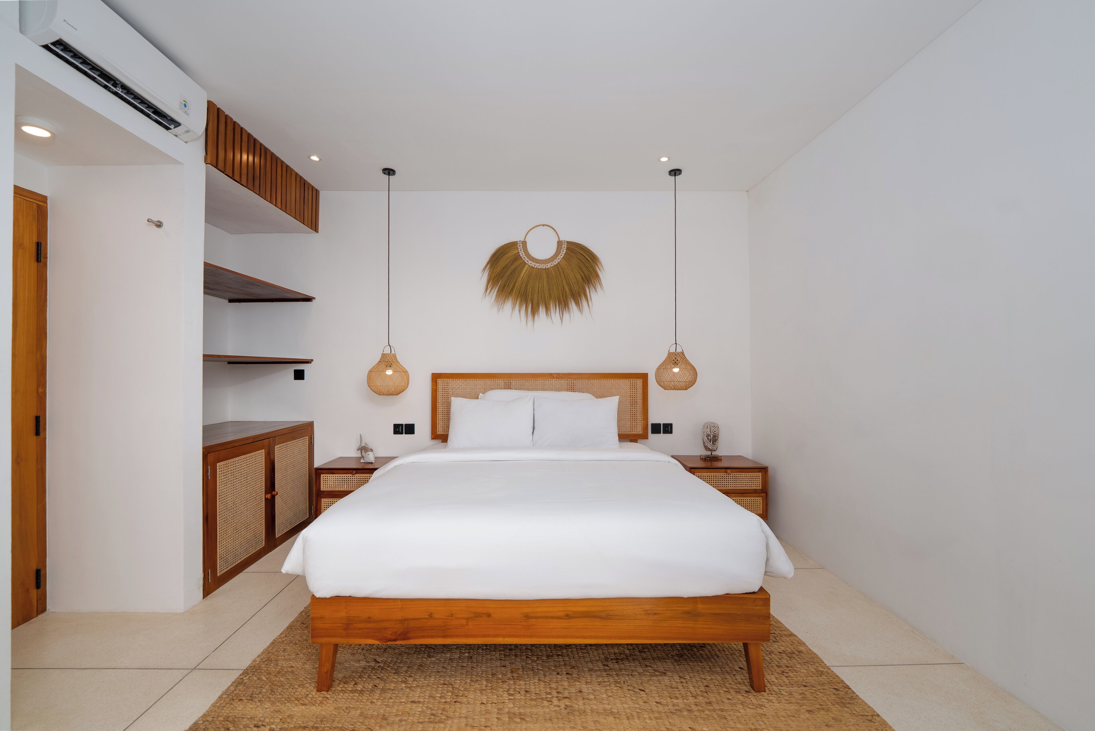 Ein Schlafzimmer mit einem hölzernen Bett, weißer Bettwäsche, einem Wanddekor und einem Einbauschrank.