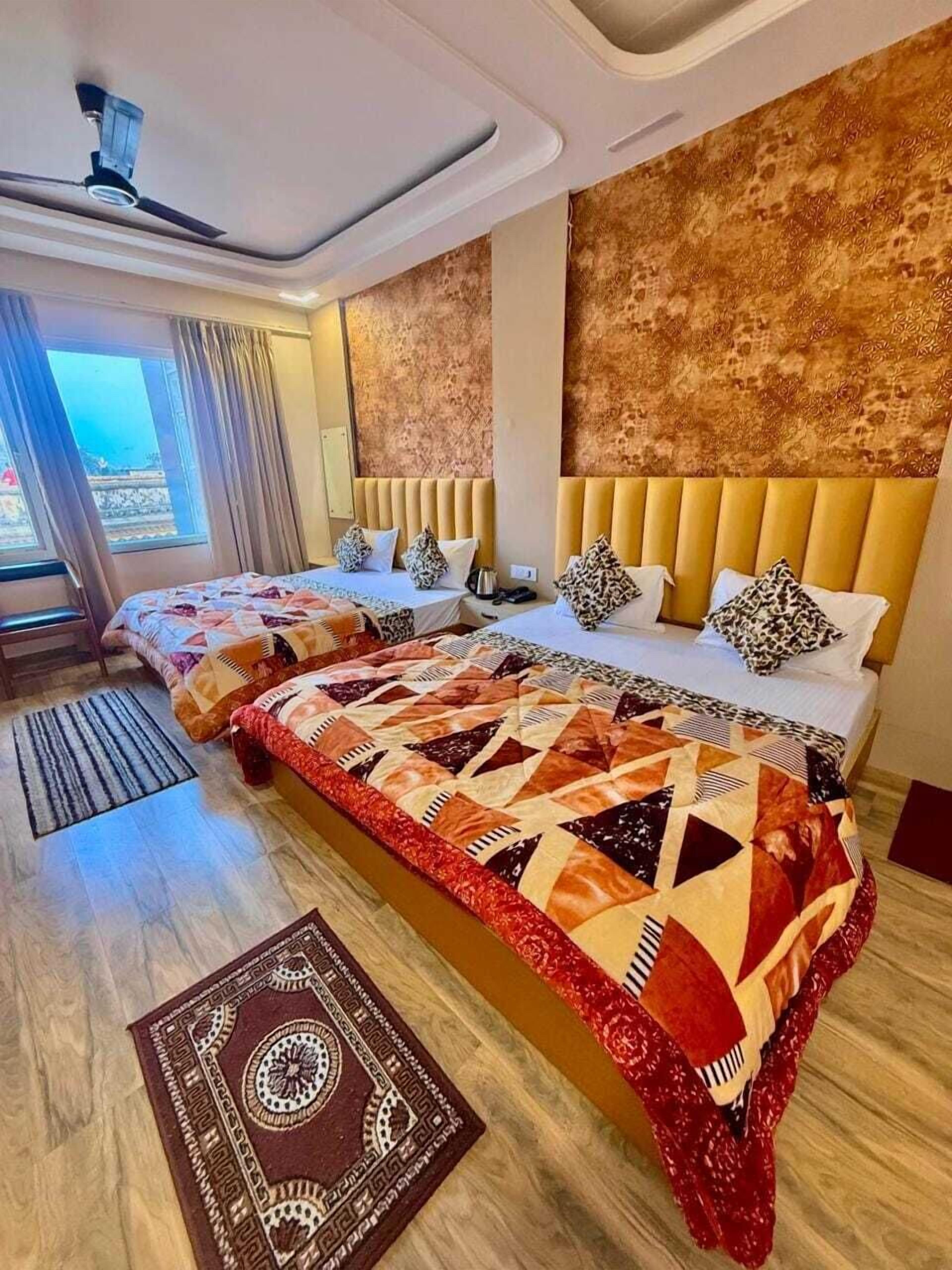 A hotel room with two beds, a patterned rug, and a view through a window.