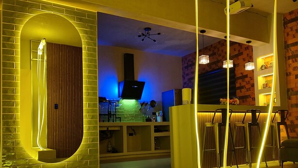 A modern interior with a staircase, a kitchen area, and a bar.