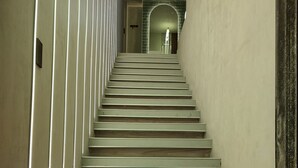A staircase with a modern design, leading to a landing area with a glass door.