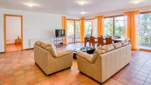 Un'ampia zona giorno con divano, tavolino e televisore.