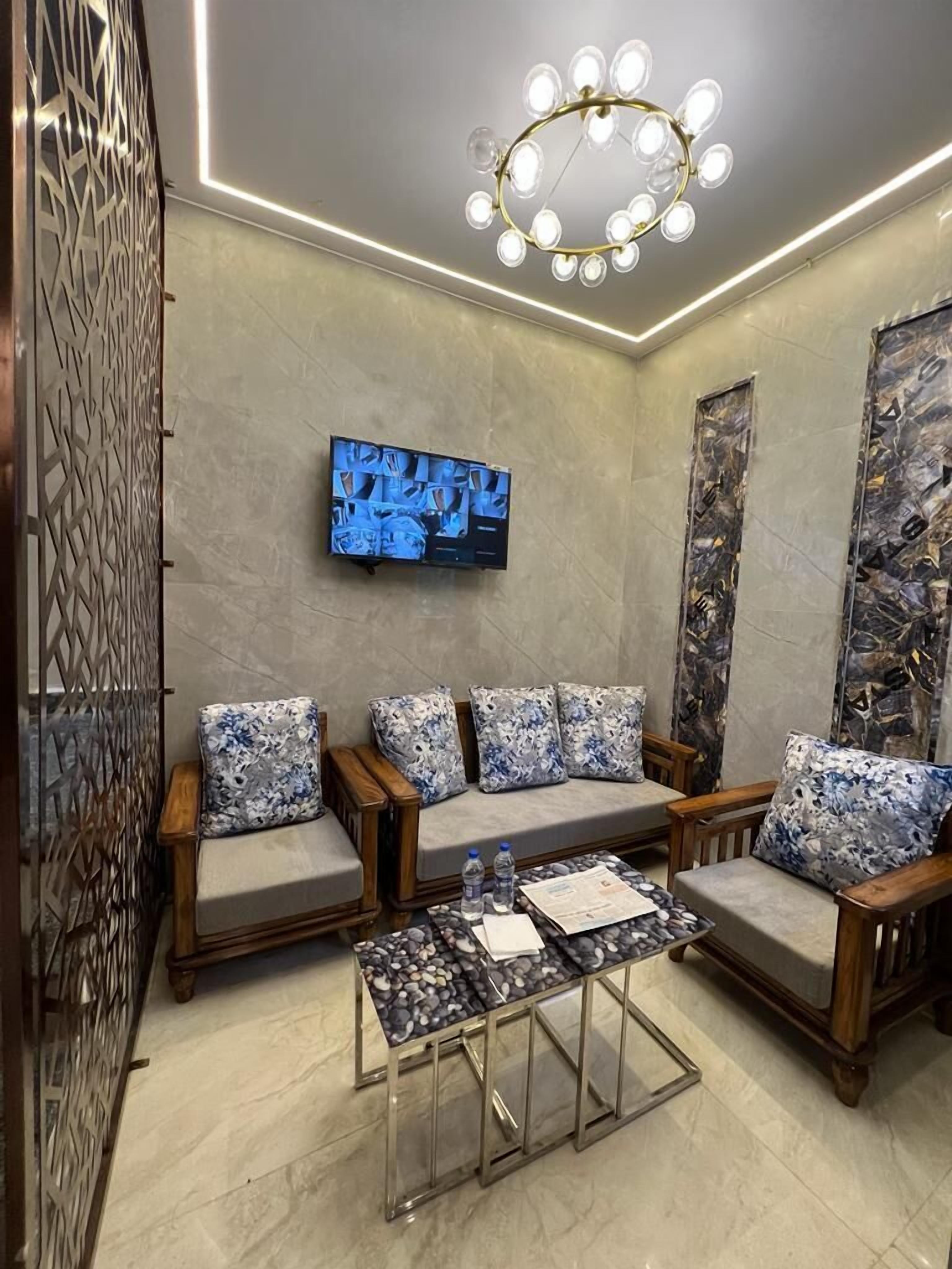 A modern living room with a sofa set, a coffee table, and a TV mounted on the wall.