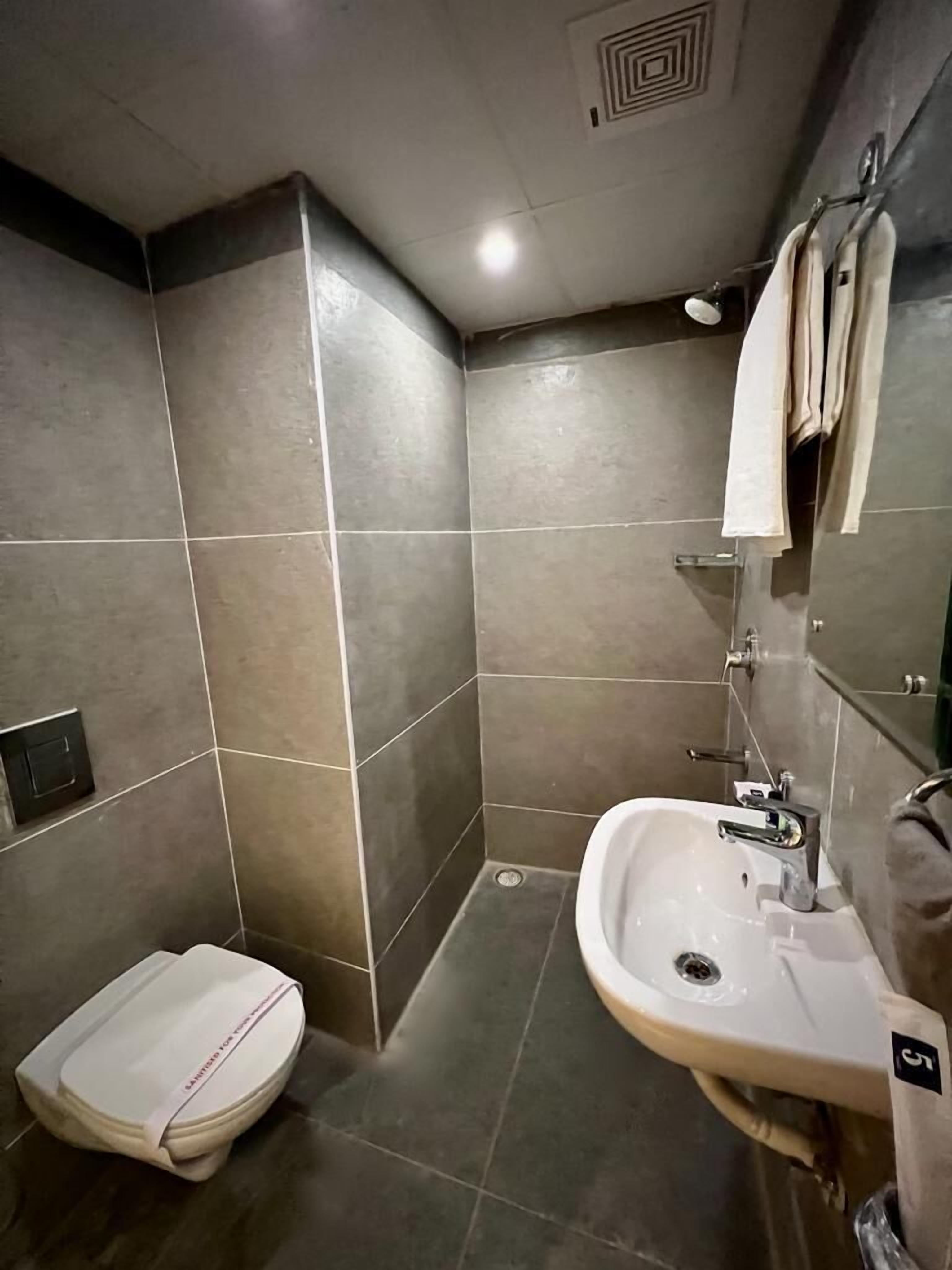 Un baño moderno con inodoro, lavamanos y toallero.