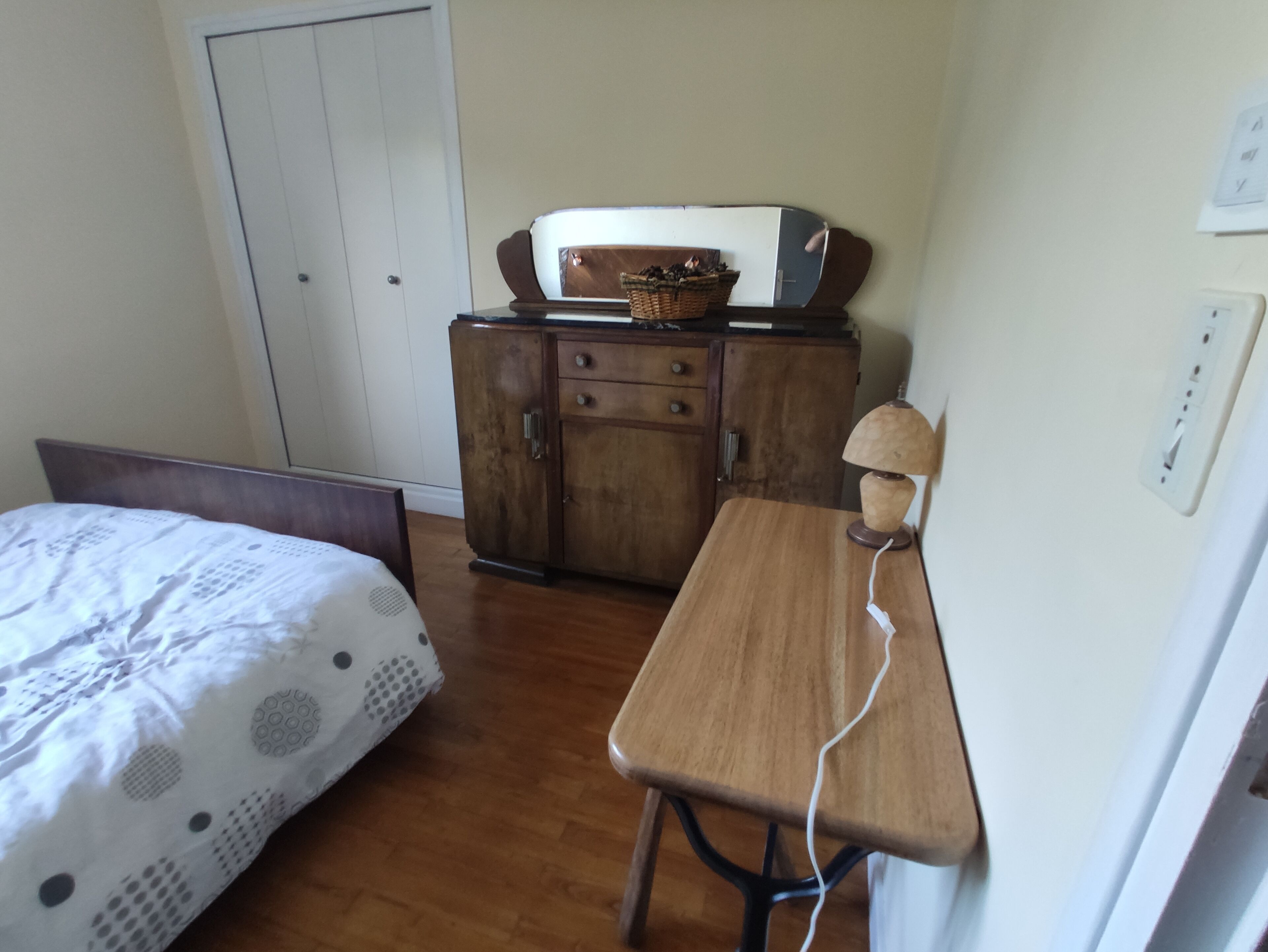 Ein Schlafzimmer mit einem Bett, einem Holztisch und einem Kleiderschrank.
