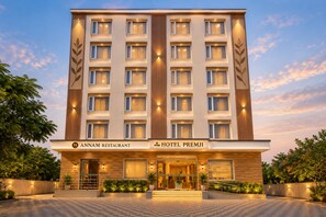 Un hôtel à plusieurs étages doté d’une façade moderne, comprenant un restaurant et un espace hall.