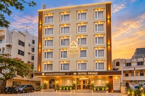 Un hôtel à plusieurs étages, avec une enseigne indiquant « Hôtel Premji » et un restaurant appelé « Annam ».