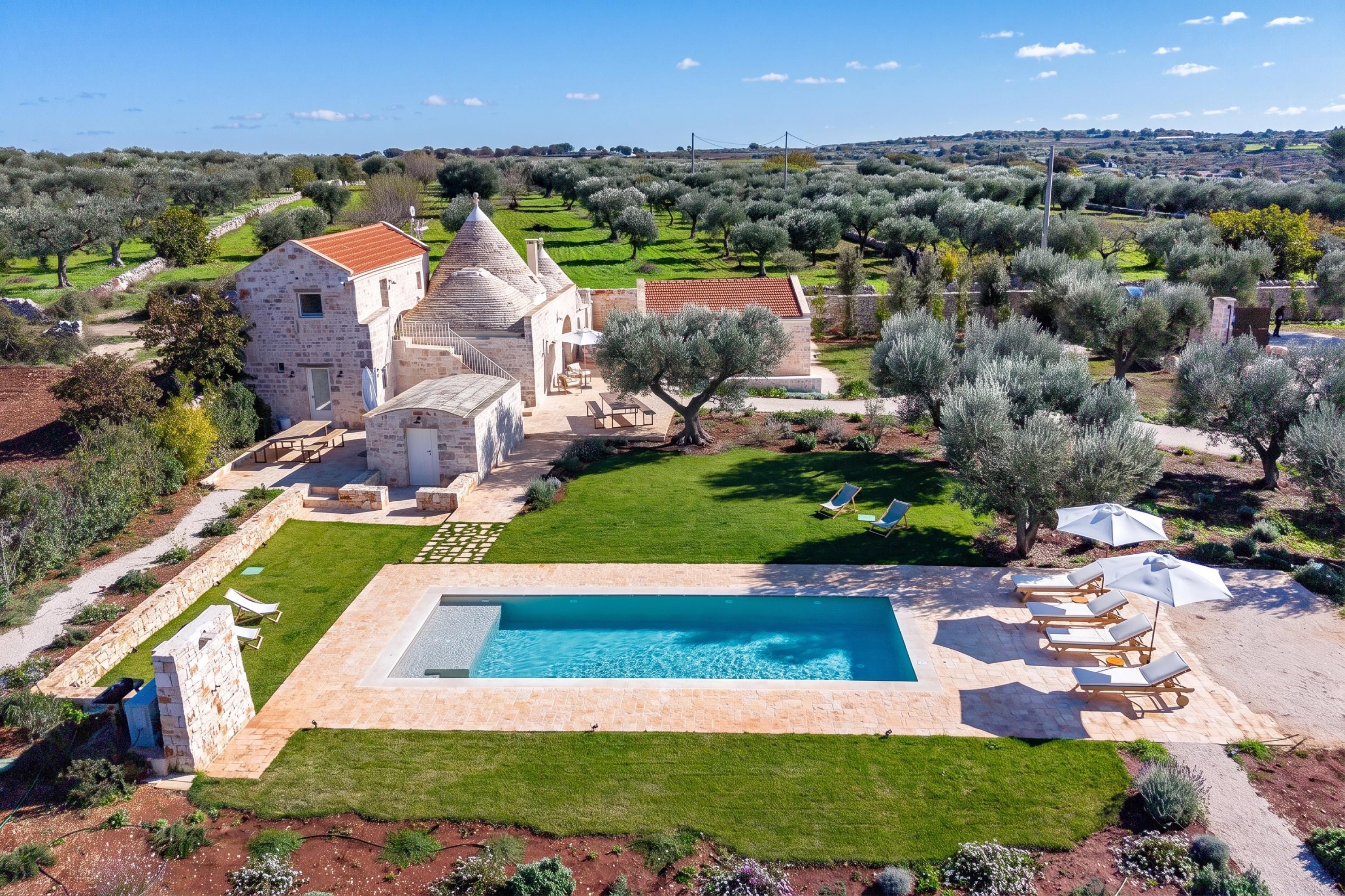 A large stone building with a swimming pool and outdoor seating.