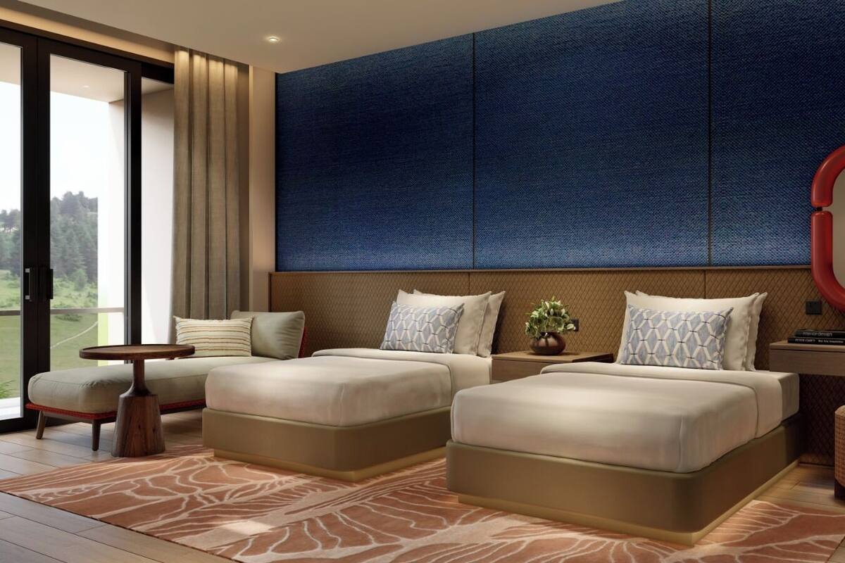 Une chambre moderne avec deux lits, une grande fenêtre et une vue sur l’extérieur.