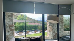 Una sala de estar moderna con un ventanal grande, un sofá y una lámpara.