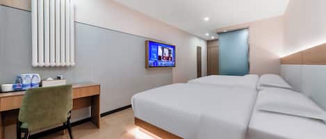 A modern hotel room with a large bed, a desk with a chair, a television, and a radiator.