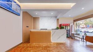 A modern reception area with a marble reception desk, a digital screen, and a view of the street outside. - Anyi (Beijing)