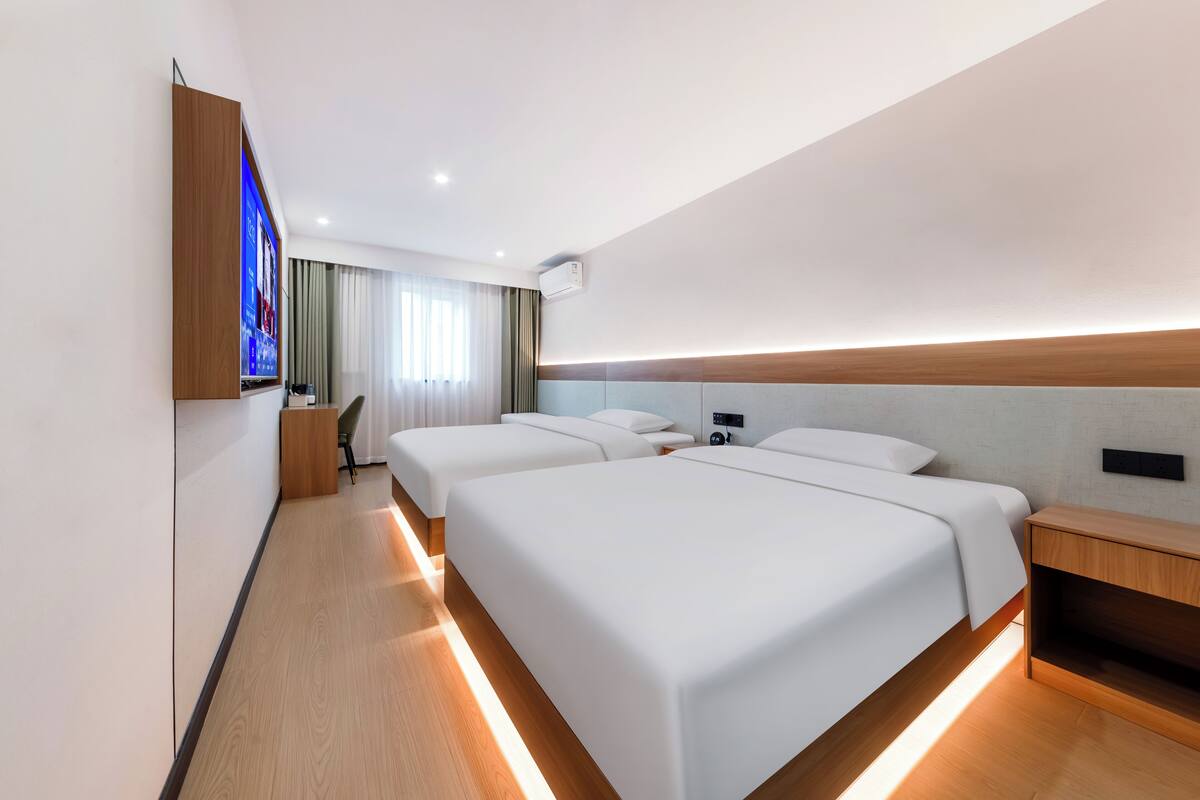 Een moderne hotelkamer met een groot bed, nachtkastjes, een flatscreen televisie en een bureau.