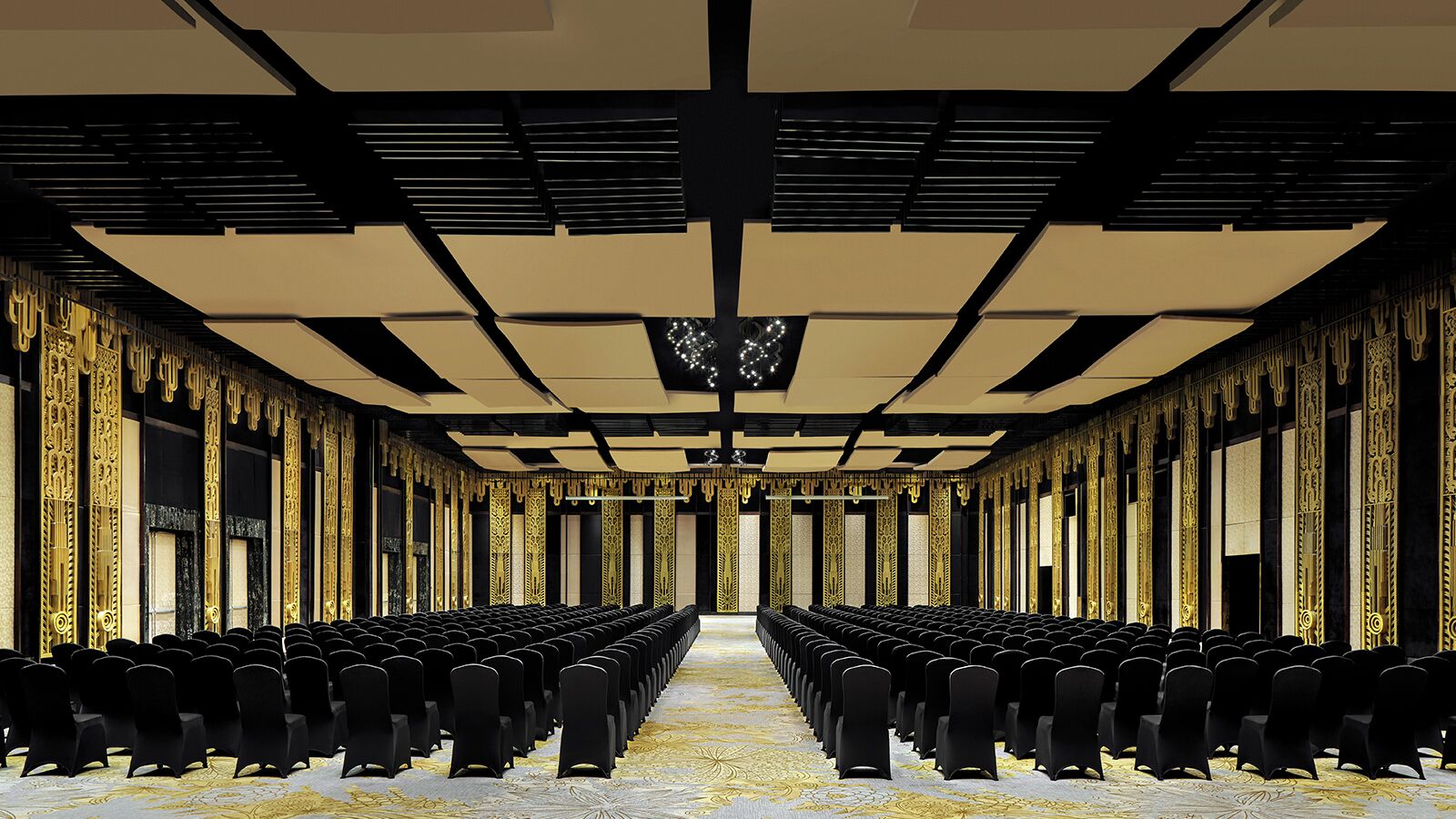 A conference room with rows of black chairs, a patterned carpet, and ornate gold detailing on the walls and ceiling.