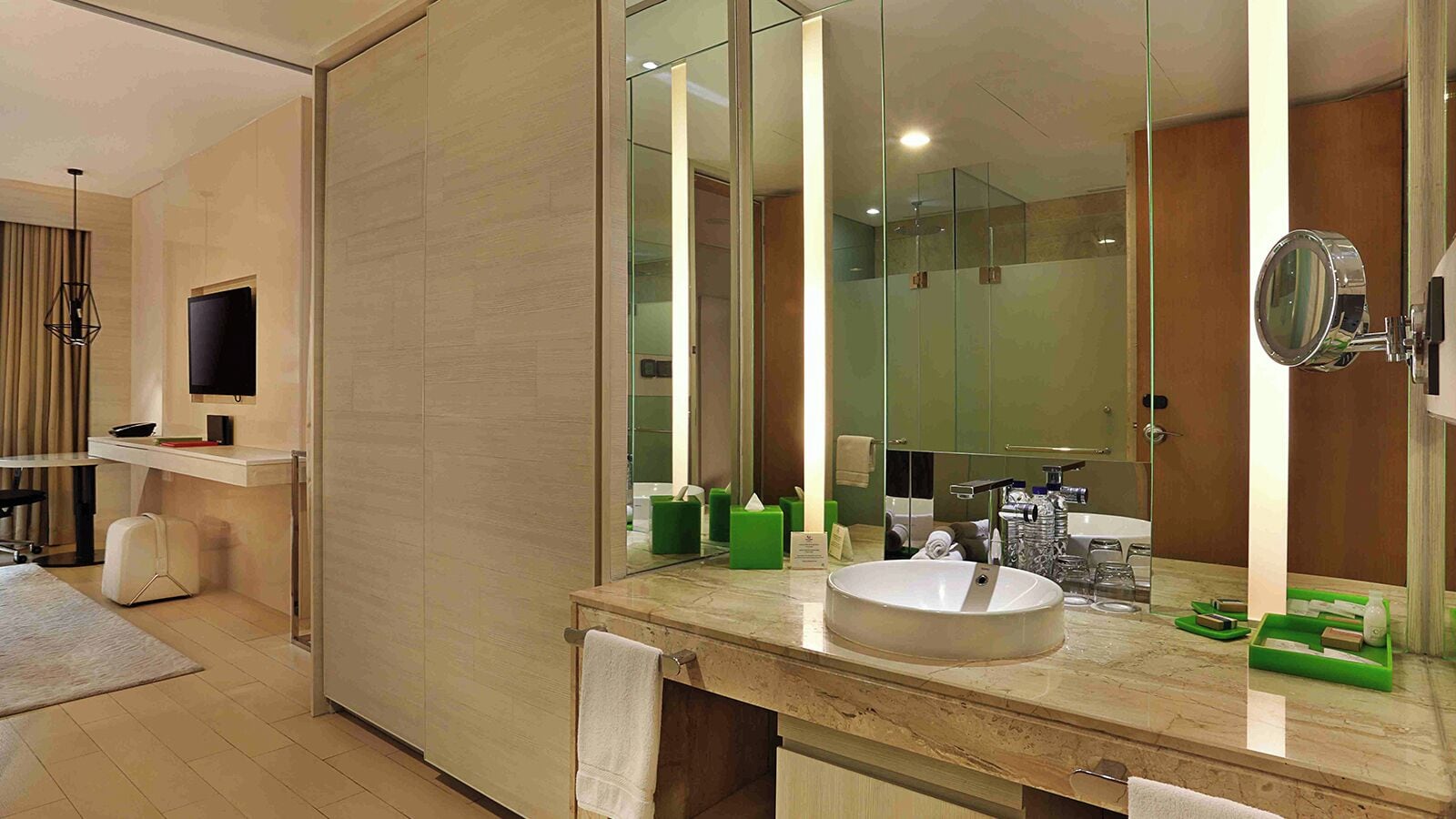 A modern bathroom with a large mirror, a sink, and a toilet.
