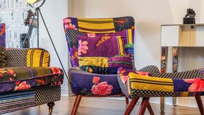 A chair with a patchwork design, a lamp, and a bookshelf. - Pontypool Haven Retreat - 3Bedroom Flat (Torfaen Principal Area)