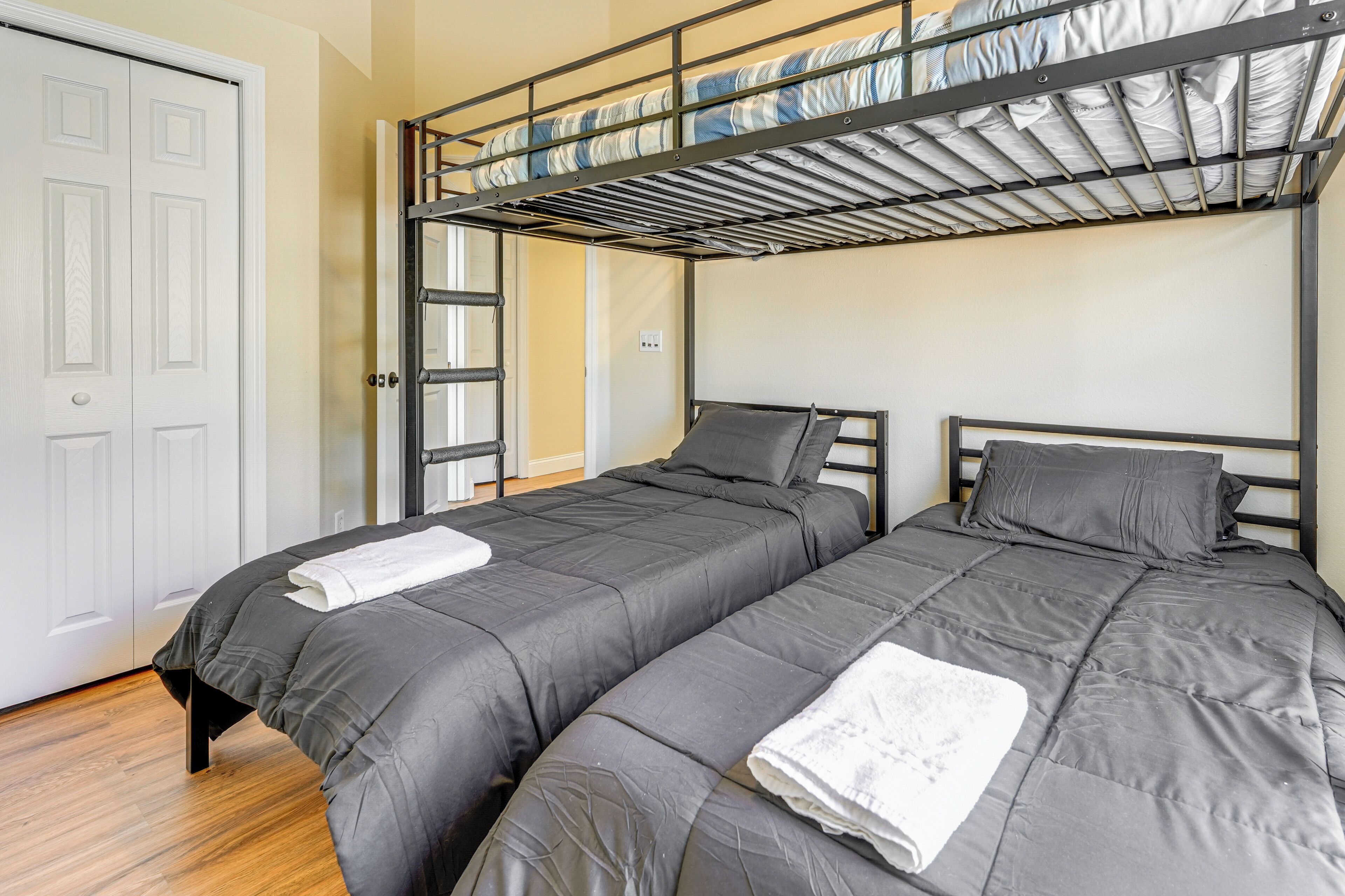 Een kamer met twee bedden, een stapelbed en een witte deur.