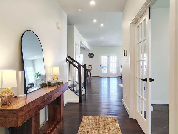 A hallway with a wooden console table, a large mirror, and a rug. - Family-Friendly Home in Quiet Neighborhood in Frederick, MD (Frederick)