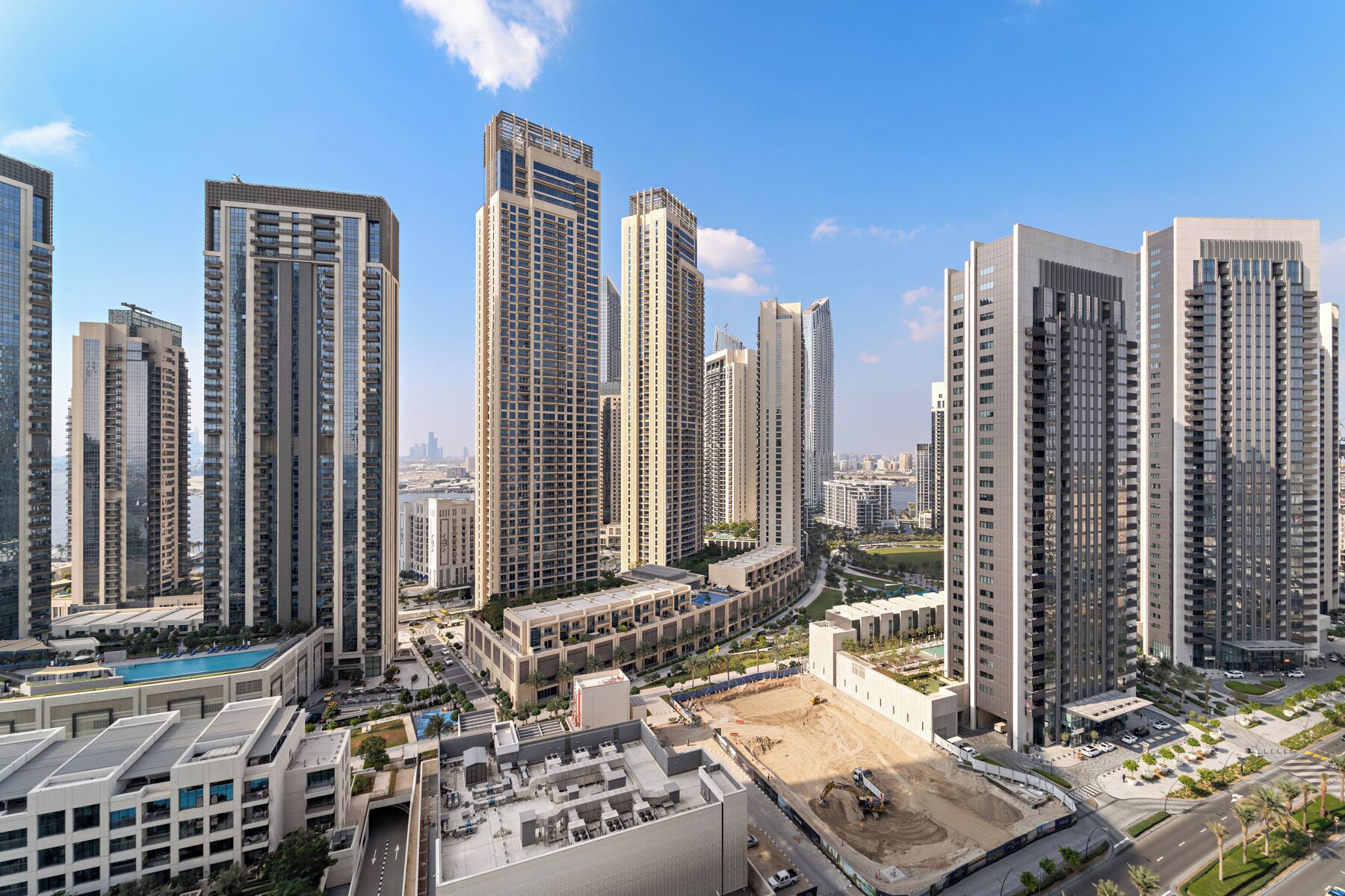 A high-rise urban area with modern buildings, a central open space, and a view of the city skyline.