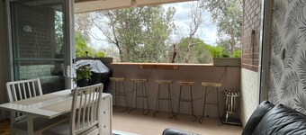 Central Location to beach & shops, quiet, balcony & bar & bar stools. Tree view.