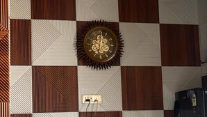 A checkered wall pattern with a clock, a ceiling fan, and a QR code for digital payments. - Hotel Kamla Kishan (Khatoo)