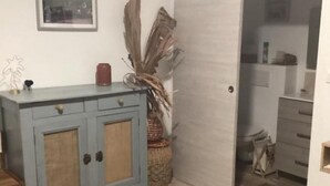 Une pièce avec un meuble bleu clair doté de deux portes, un panier en osier et une porte donnant sur une autre pièce.