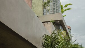 A modern building with a curved facade and a cylindrical section with a glass window. - Patha (Canggu)