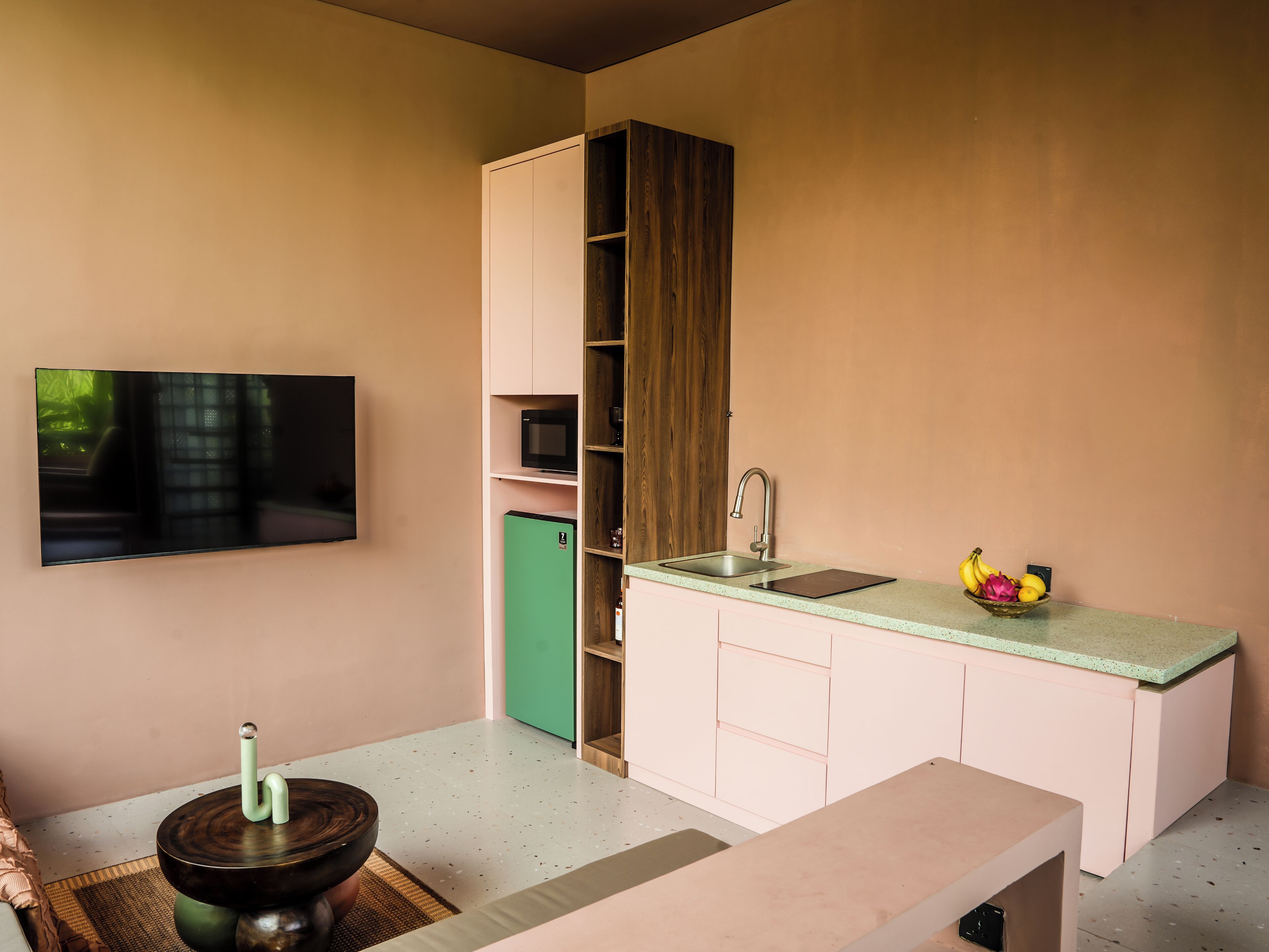 A compact kitchenette with a microwave, refrigerator, and sink.