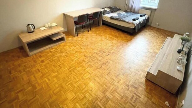Una habitación pequeña con cama, escritorio y una zona de estar.