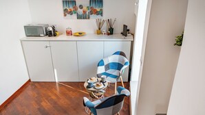 A compact kitchen with a microwave, coffee maker, and a small dining area with two chairs and a table. - Tresor 39 - Blanco (Polignano a Mare)
