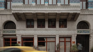 Un bâtiment de style architectural traditionnel, caractérisé par des fenêtres en arc et des motifs décoratifs en carreaux.