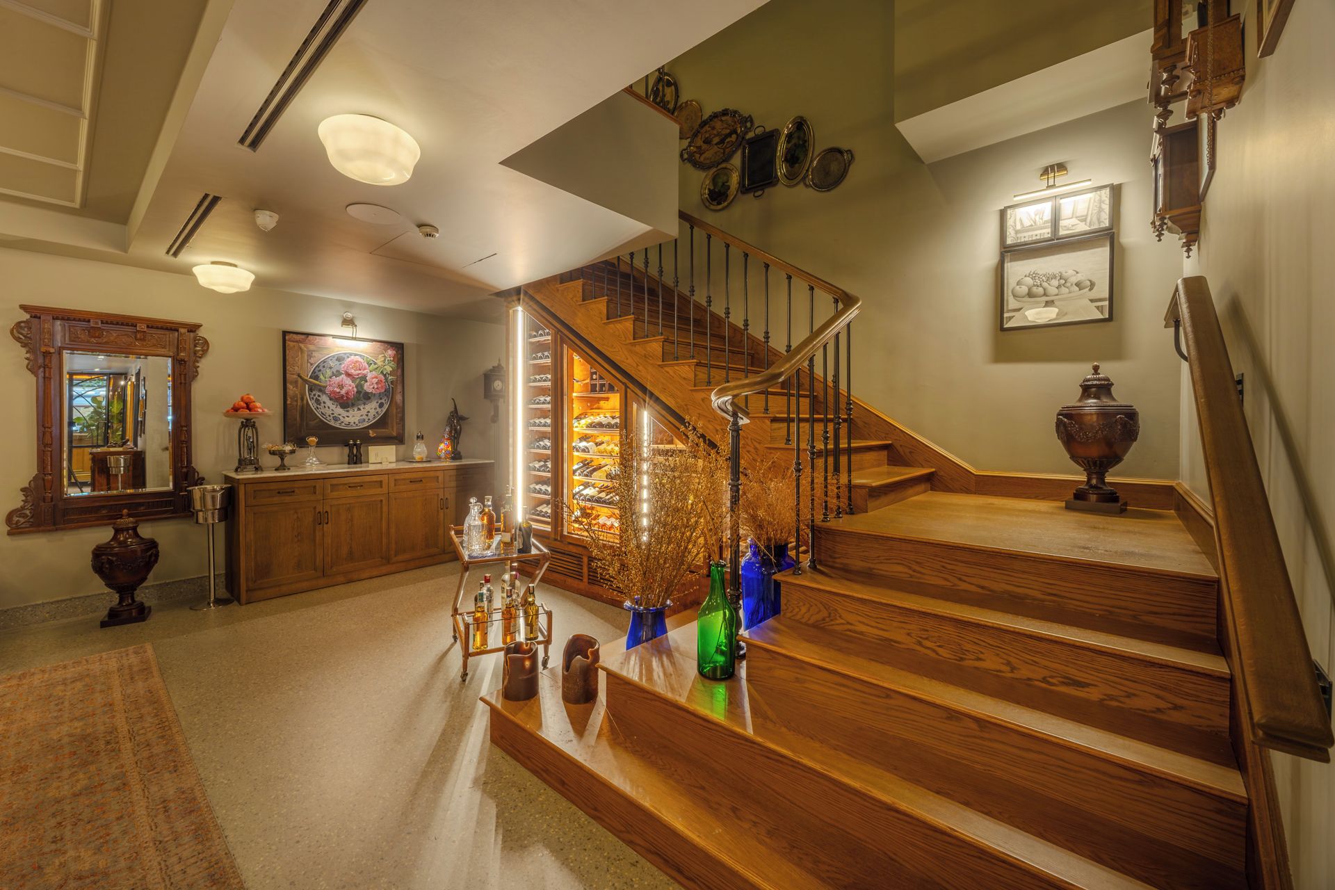 A grand staircase with wooden steps and a glass railing, leading to a second floor.
