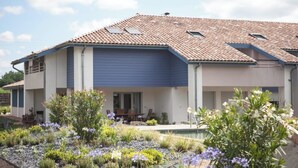 A modern two-story house with a tiled roof, a covered patio, and a swimming pool. - Entre Plages & Espagne : Ferme de Charme, Pistes cyclables & Baignade Bio (Orx)