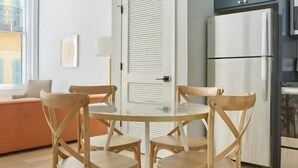 Una cocina moderna con un refrigerador blanco, sillas de madera y una mesa de comedor.