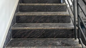 A staircase with dark marble steps and a metal railing. - Devi Heritage Vrindavan (Vrindavan)