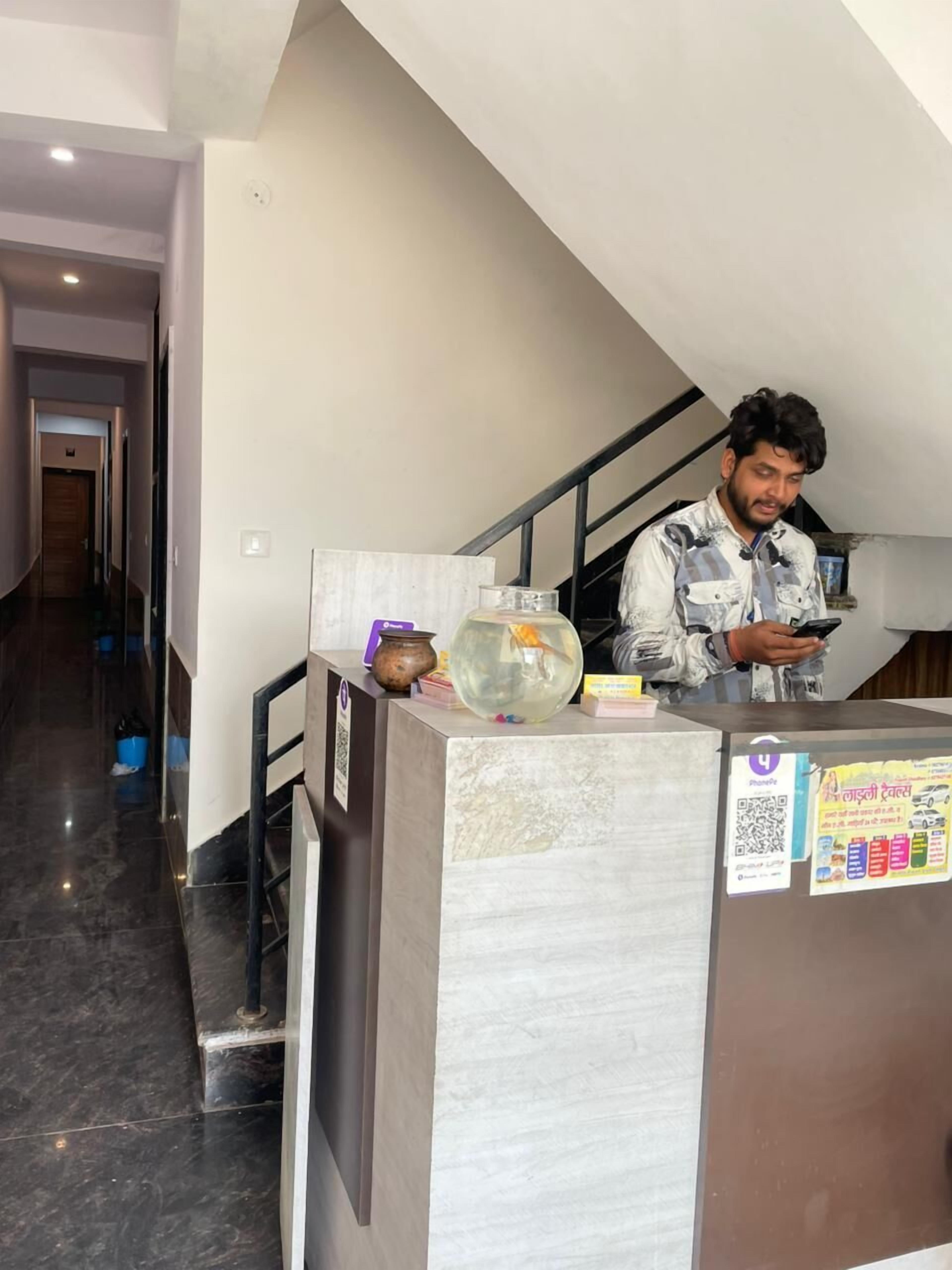 A reception area with a marble counter, a fish bowl, and a poster with a QR code.