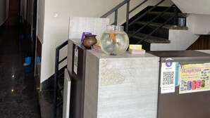 A modern hotel lobby with a marble floor, a reception desk, a staircase, and a wall-mounted sign. - Devi Heritage Vrindavan (Vrindavan)