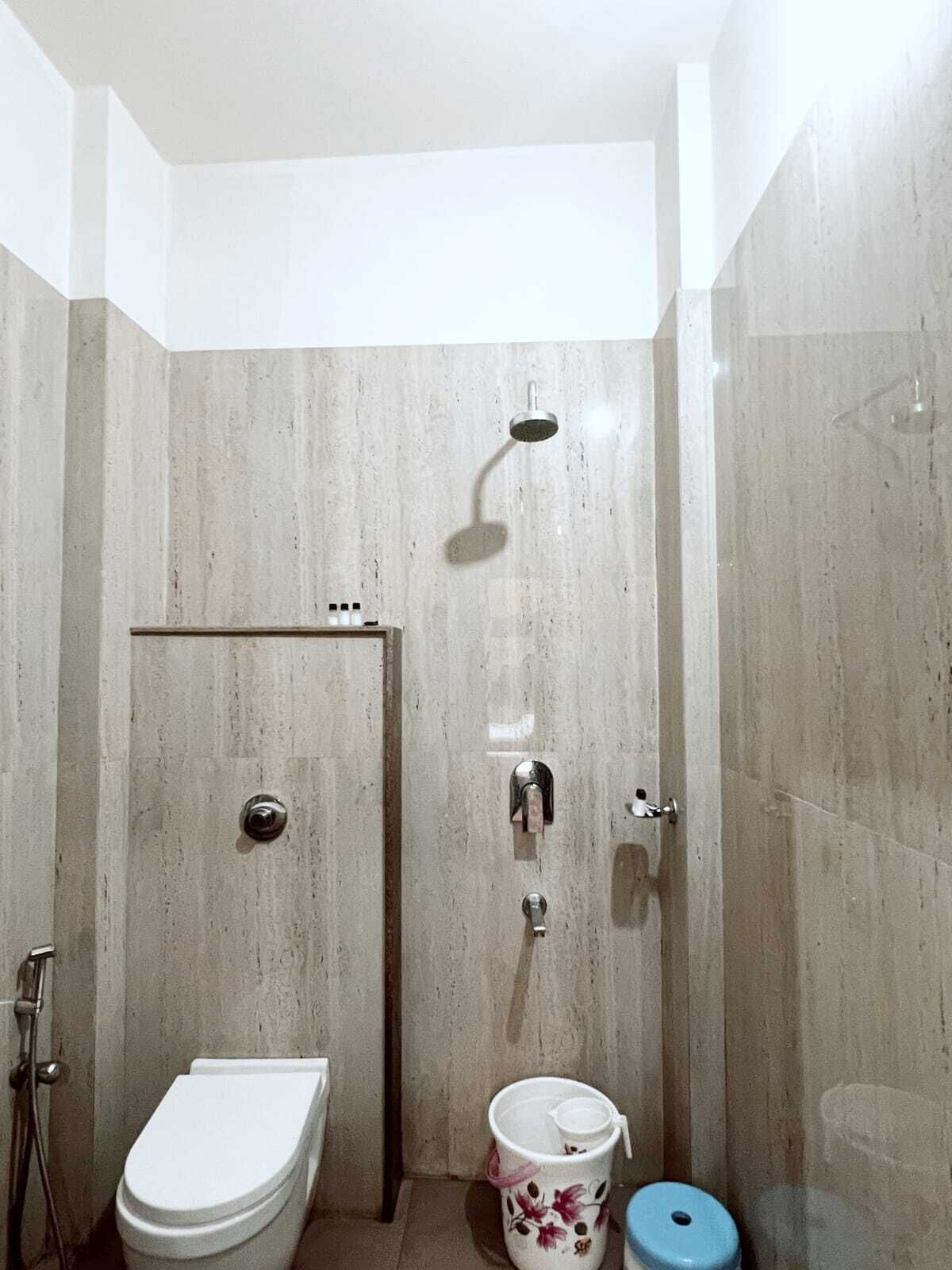 Un bagno con un water, una doccia e un lavandino.
