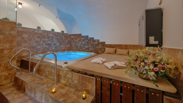 Ein Wellnessbereich mit Whirlpool, einer Holztresen und einer Blumenkomposition.