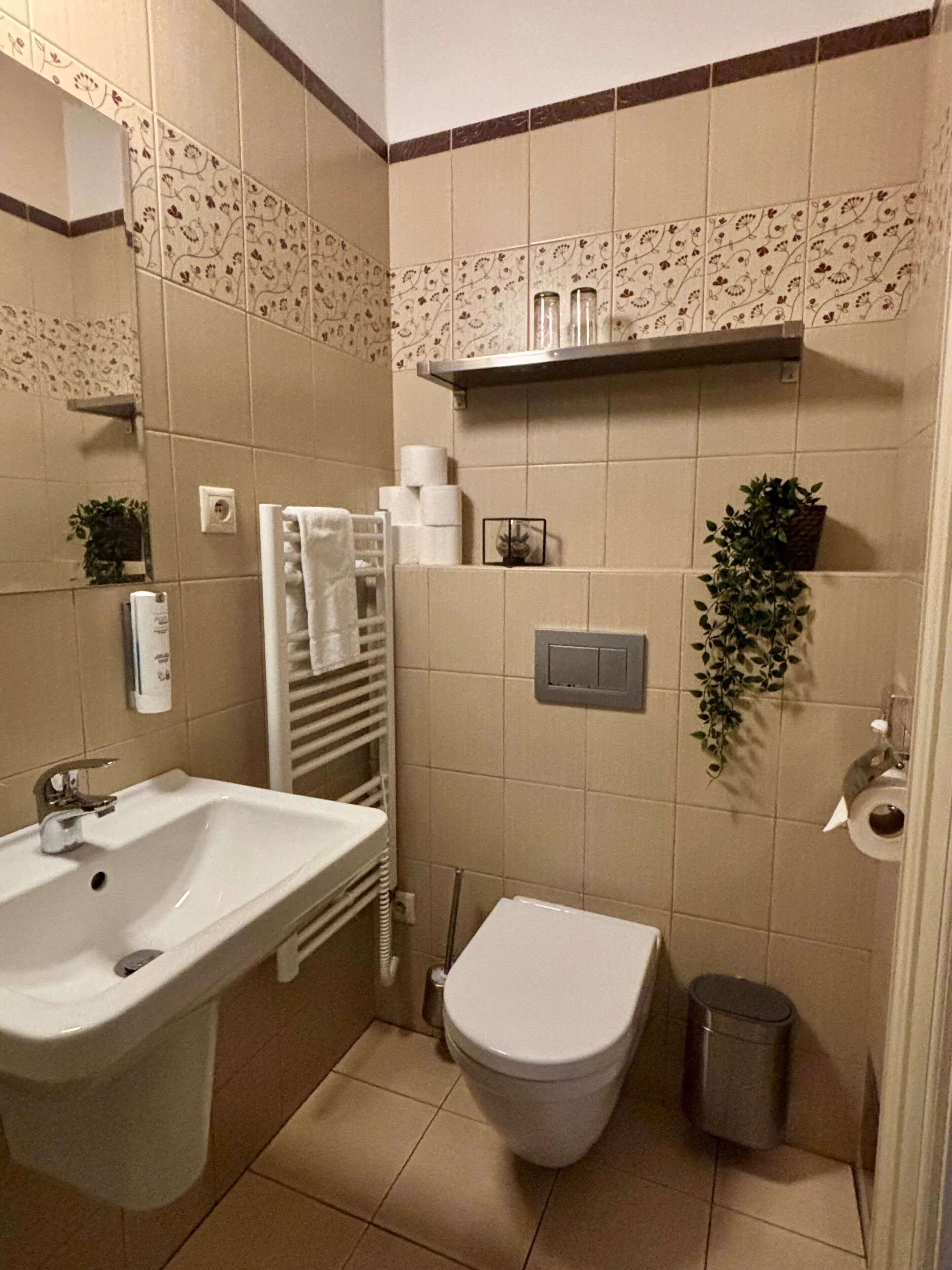 A bathroom with a sink, toilet, and a towel rack.