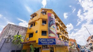 A yellow building with a sign for QISH HOTEL and BANDA KABA. - OYO 91258 Qish Hotel Banda Kaba (Malacca City)