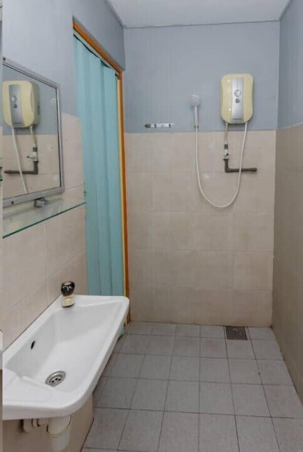 A small bathroom with a sink, a mirror, a shower, and a towel dispenser. - OYO 91258 Qish Hotel Banda Kaba (Malacca City)