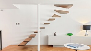 A modern staircase with wooden steps descending from a white column. - Architect design maisonette in top location in Holland Park (London)