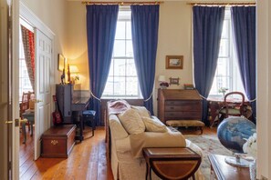 A room with a sofa, a wooden chest, a globe, and a window with curtains. - Classic 2 BDR Georgian Flat in Central Edinburgh (Edinburgh)