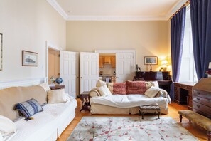Ein gemütliches Wohnzimmer mit einer Couch, einem Couchtisch und einem Essbereich mit Tisch und Stühlen.